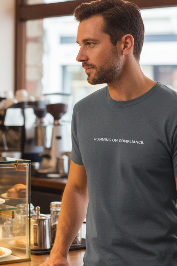 Caucasian man in coffee shop wearing RUNNING ON COMPLIANCE shirt